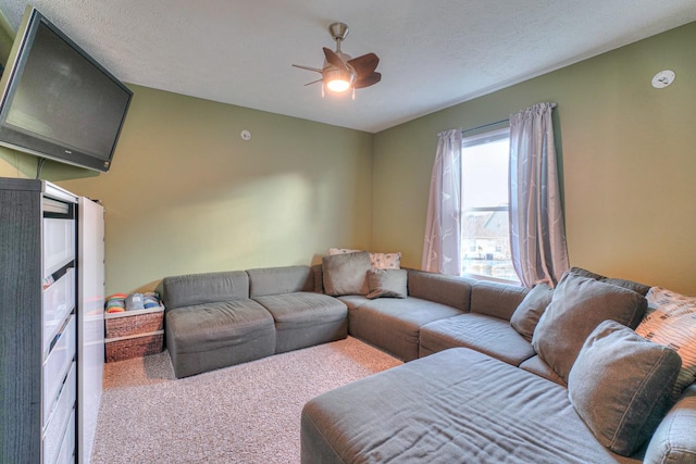 living room featuring a textured ceiling, carpet floors, and ceiling fan