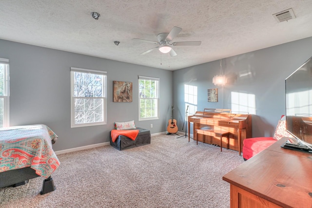 bedroom with ceiling fan, light colored carpet, and a textured ceiling