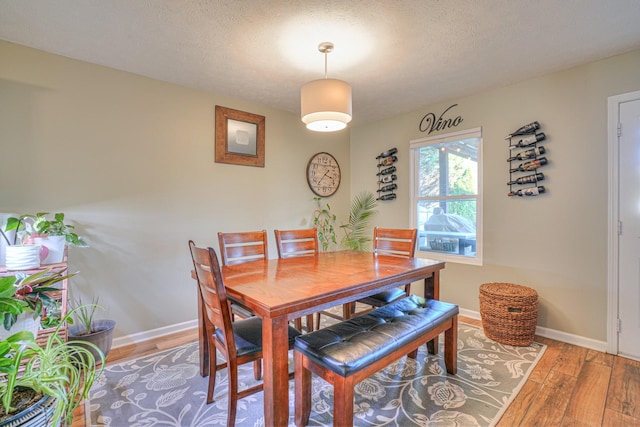 dining room featuring hardwood / wood-style floors and a textured ceiling