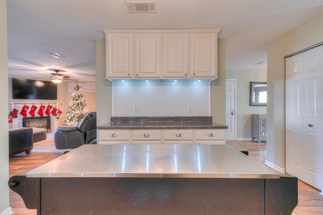 kitchen featuring white cabinets, ceiling fan, light hardwood / wood-style floors, and a kitchen island