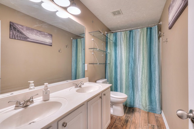 bathroom featuring vanity, a shower with shower curtain, a textured ceiling, and toilet