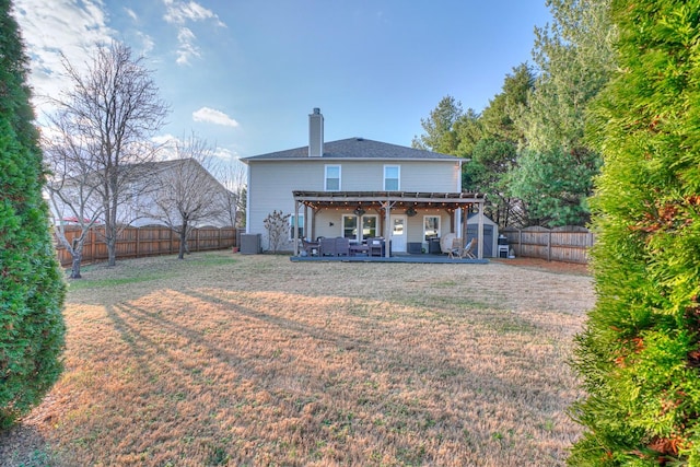 rear view of property featuring central AC, a storage unit, a patio area, and a lawn