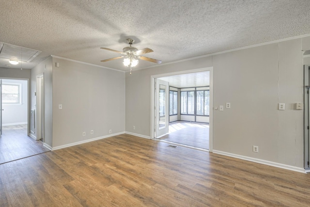 empty room with wood-type flooring, a textured ceiling, ceiling fan, and crown molding