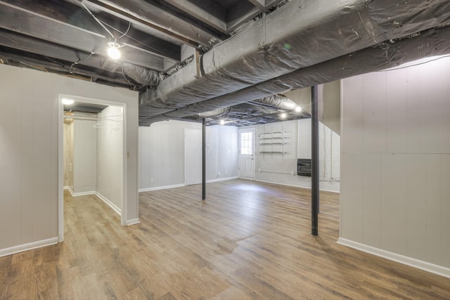 below grade area with baseboards and wood finished floors