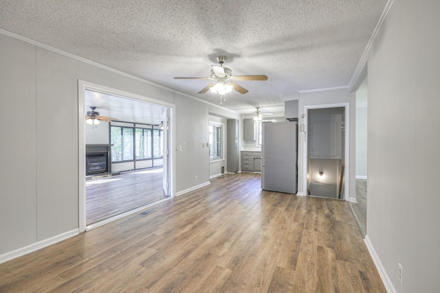 unfurnished living room featuring a textured ceiling, hardwood / wood-style flooring, and crown molding