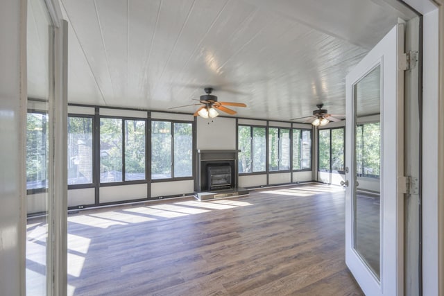 unfurnished living room featuring a fireplace with raised hearth and wood finished floors