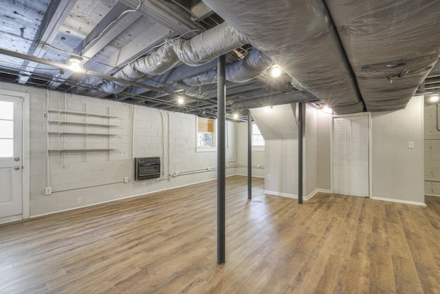 basement with heating unit and hardwood / wood-style floors