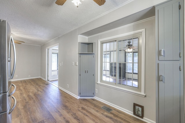 entrance foyer featuring visible vents, ceiling fan, a textured ceiling, and wood finished floors