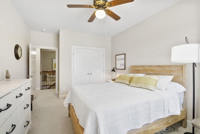 bedroom featuring ceiling fan, light carpet, and a closet