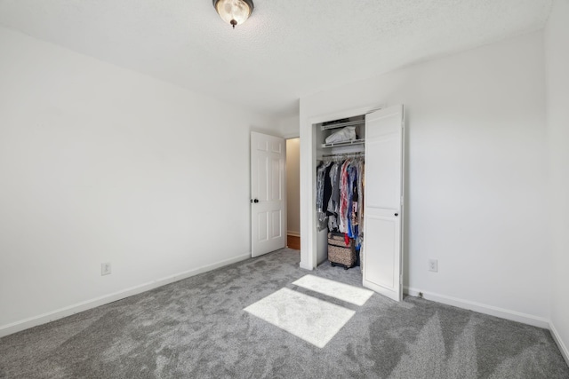 unfurnished bedroom with carpet flooring, a textured ceiling, and a closet