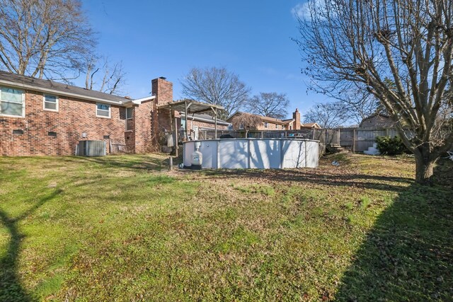 view of yard with a fenced in pool and central AC