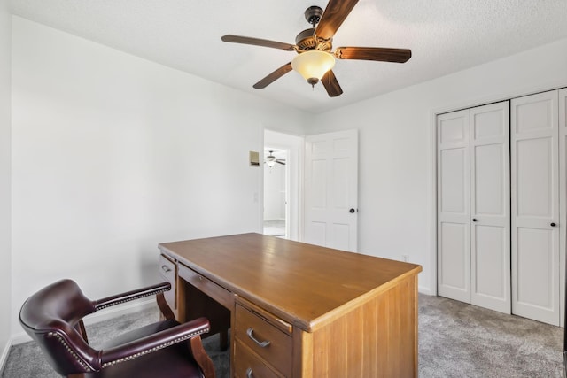 office featuring a textured ceiling, light colored carpet, and ceiling fan