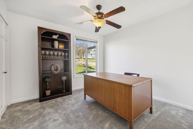 office space with light carpet, ceiling fan, and a textured ceiling