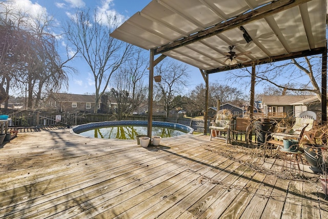 wooden deck featuring a fenced in pool and ceiling fan