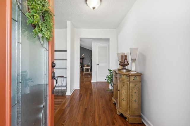 hallway with a textured ceiling and dark wood-type flooring