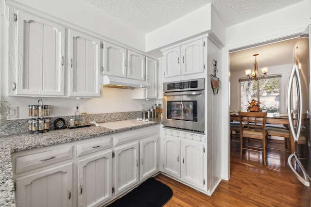 kitchen featuring a chandelier, appliances with stainless steel finishes, white cabinetry, and hardwood / wood-style floors