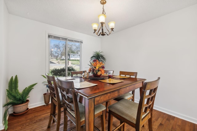 dining space featuring a textured ceiling, an inviting chandelier, and dark wood-type flooring