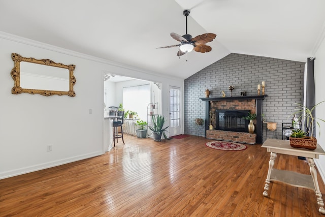 living room featuring hardwood / wood-style flooring, a brick fireplace, ceiling fan, and lofted ceiling