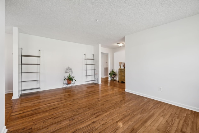 empty room with a textured ceiling and hardwood / wood-style flooring