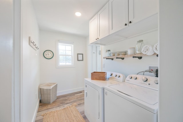 washroom featuring washer and dryer, light hardwood / wood-style floors, and cabinets