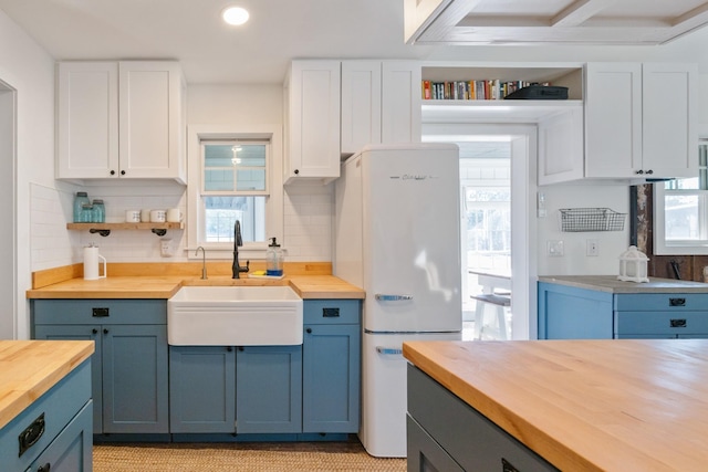 kitchen with white cabinetry, sink, a healthy amount of sunlight, and wood counters