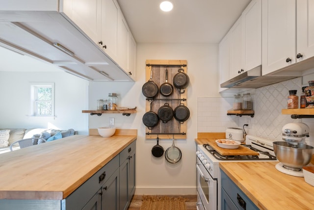 kitchen with gray cabinetry, white cabinetry, wooden counters, backsplash, and stainless steel stove