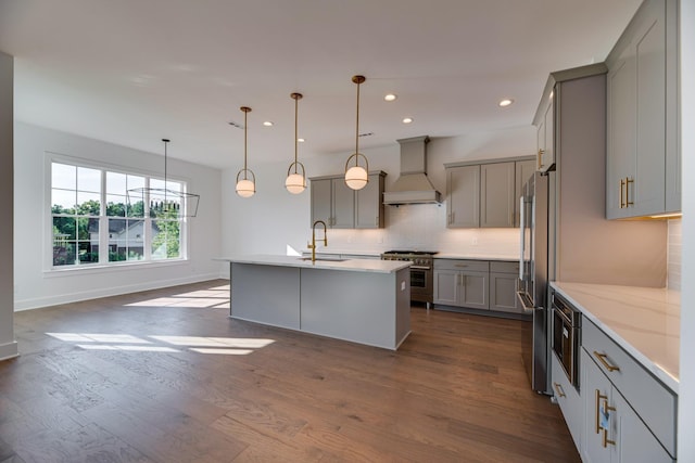 kitchen featuring premium range hood, high quality appliances, sink, and decorative light fixtures