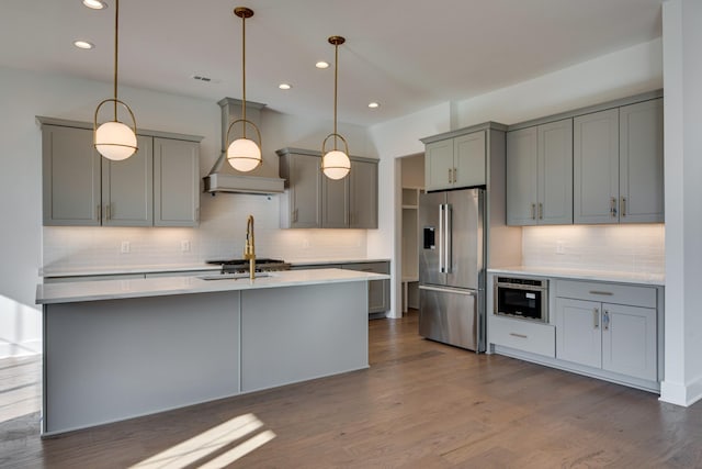 kitchen with gray cabinetry, custom exhaust hood, stainless steel appliances, dark wood-type flooring, and pendant lighting