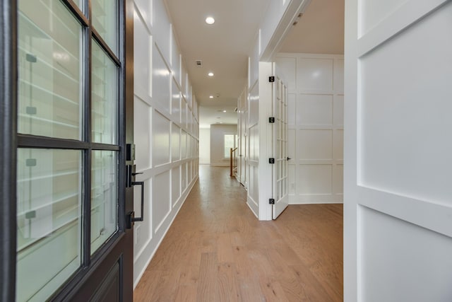 corridor with light hardwood / wood-style floors