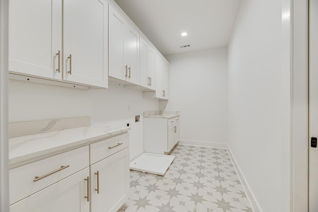 laundry room featuring hookup for an electric dryer and cabinets