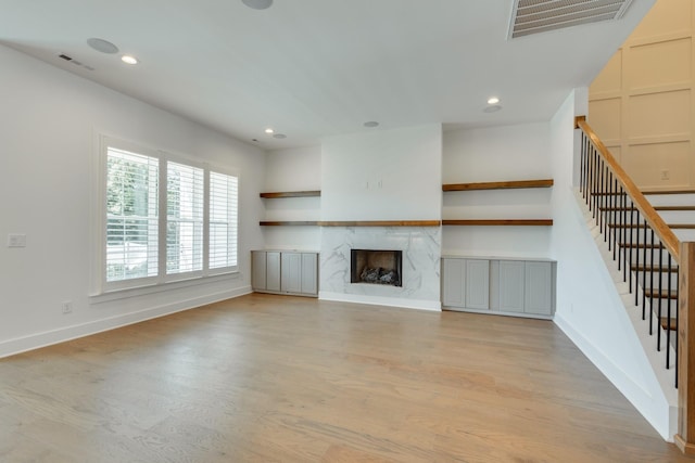 unfurnished living room with light wood-type flooring and a premium fireplace