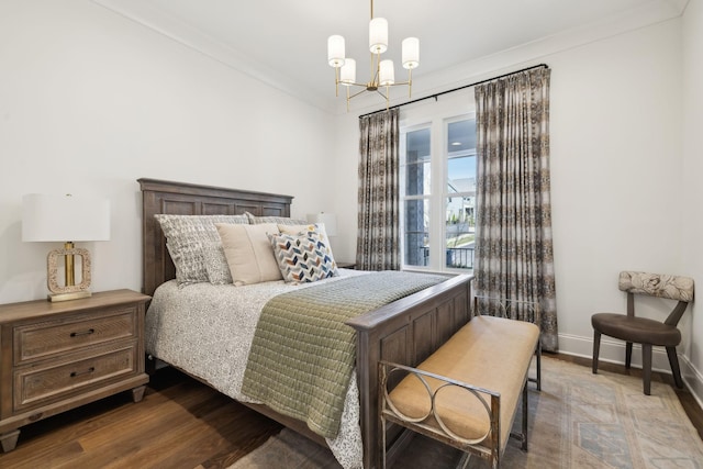 bedroom with ornamental molding, wood-type flooring, and a notable chandelier