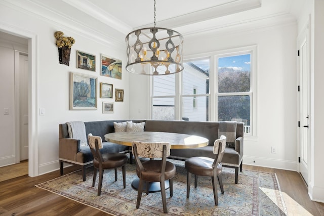 dining room featuring an inviting chandelier, dark hardwood / wood-style flooring, crown molding, and breakfast area