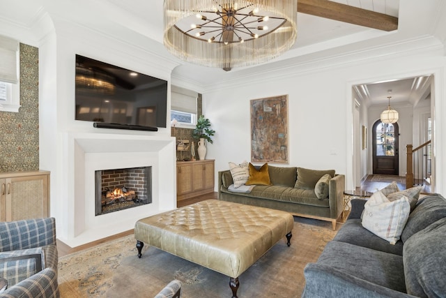 living room with beam ceiling, an inviting chandelier, crown molding, and hardwood / wood-style floors