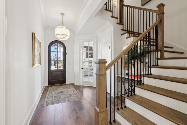 entryway featuring dark wood-type flooring and crown molding