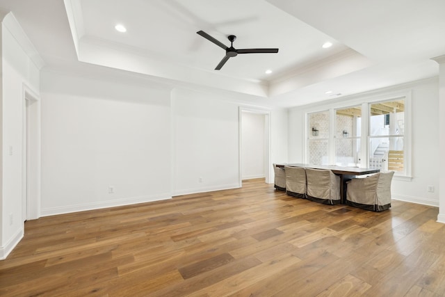 interior space with ceiling fan, hardwood / wood-style floors, crown molding, and a raised ceiling