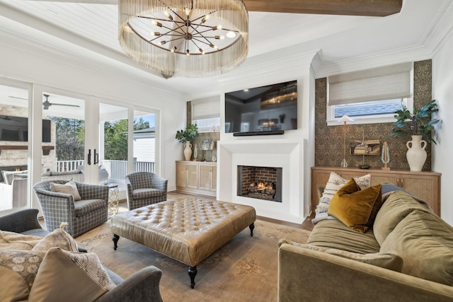 living room with french doors, a notable chandelier, ornamental molding, and hardwood / wood-style flooring