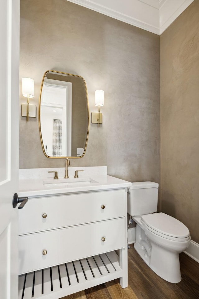 bathroom with toilet, ornamental molding, hardwood / wood-style flooring, and vanity