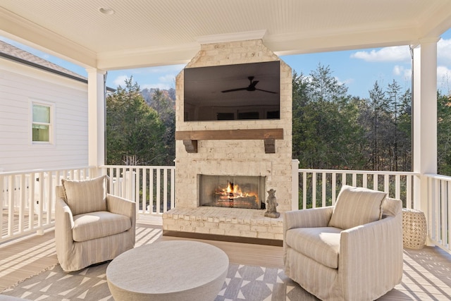 exterior space featuring an outdoor brick fireplace and ceiling fan