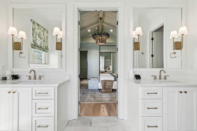 bathroom featuring vanity, ornamental molding, and vaulted ceiling