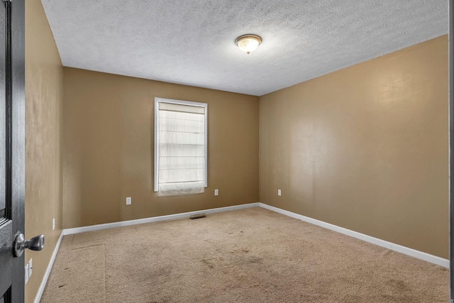 carpeted empty room featuring a textured ceiling