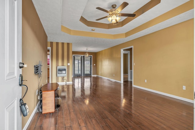 entrance foyer featuring dark hardwood / wood-style flooring, ceiling fan, a raised ceiling, and heating unit