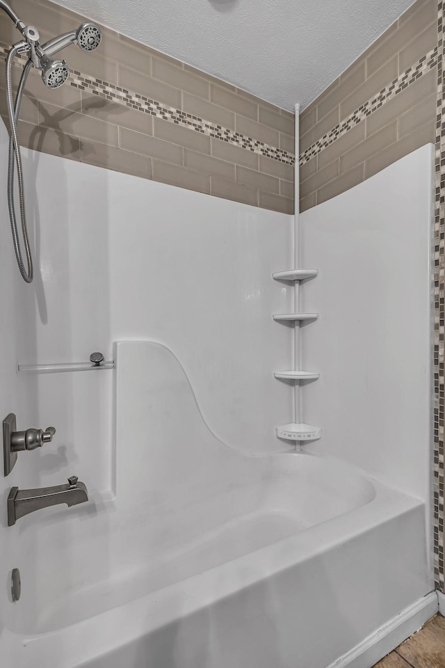 bathroom featuring a textured ceiling and shower / washtub combination