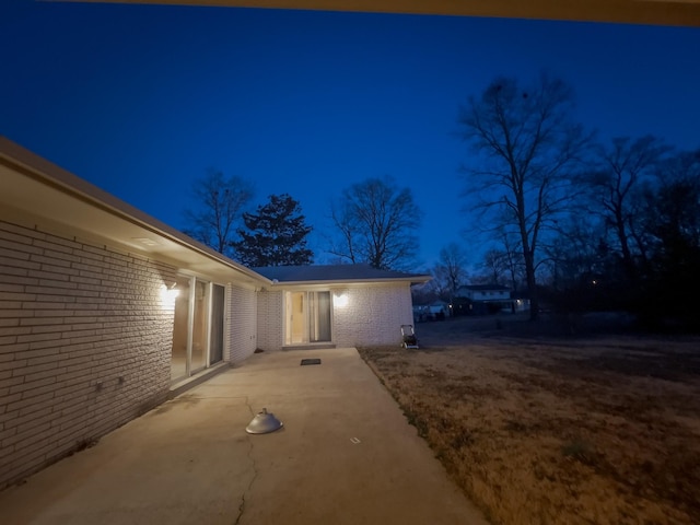 property exterior at twilight featuring a patio area