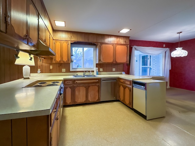 kitchen with stainless steel dishwasher, decorative light fixtures, kitchen peninsula, and sink