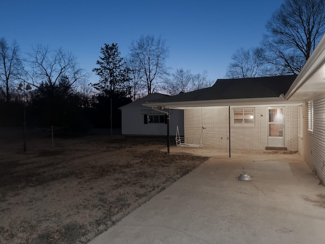 property exterior at dusk featuring a patio