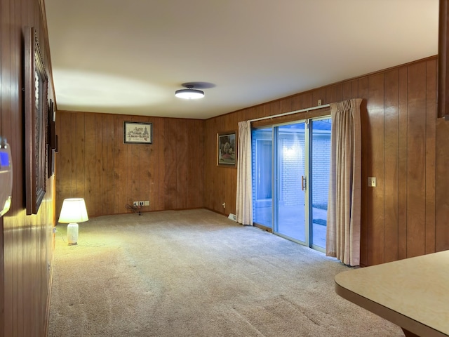 carpeted empty room with wood walls