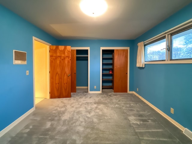 unfurnished bedroom featuring carpet and two closets