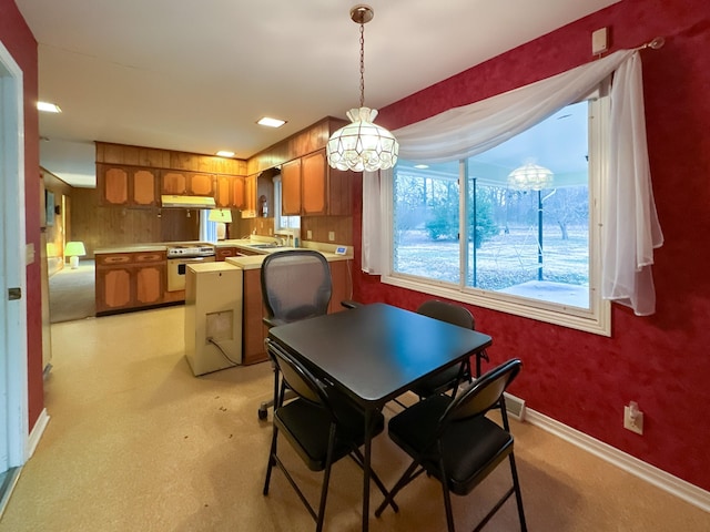 dining space featuring an inviting chandelier, light colored carpet, and sink