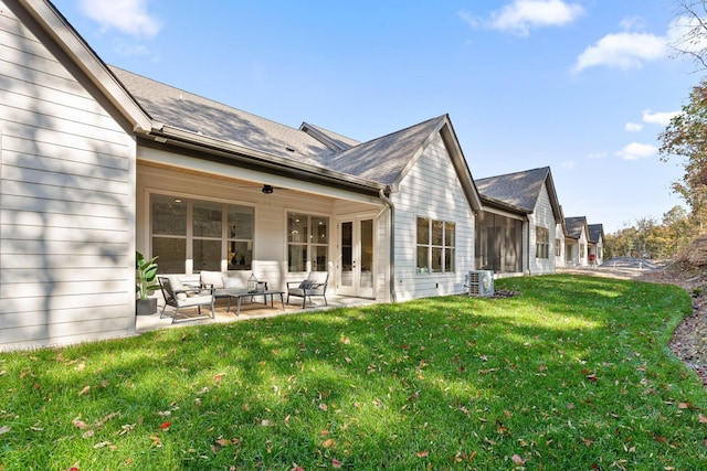 back of property with an outdoor living space, a yard, cooling unit, and a patio